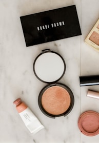photo of assorted makeup products on gray surface